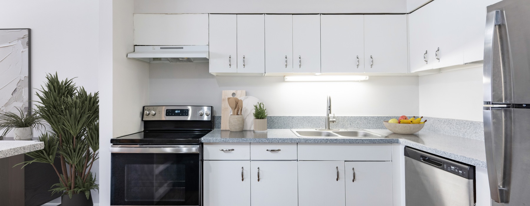 Open kitchen with white cabinets and granite style countertops and stainless steel appliances