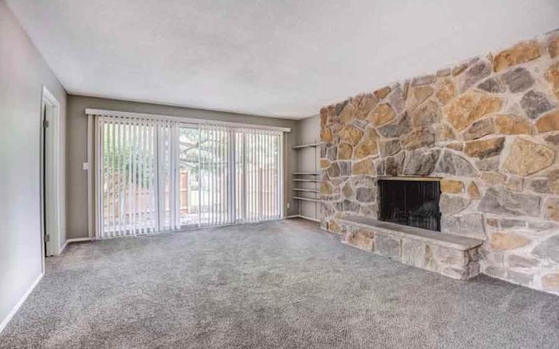 a empty room with a stone wall fireplace