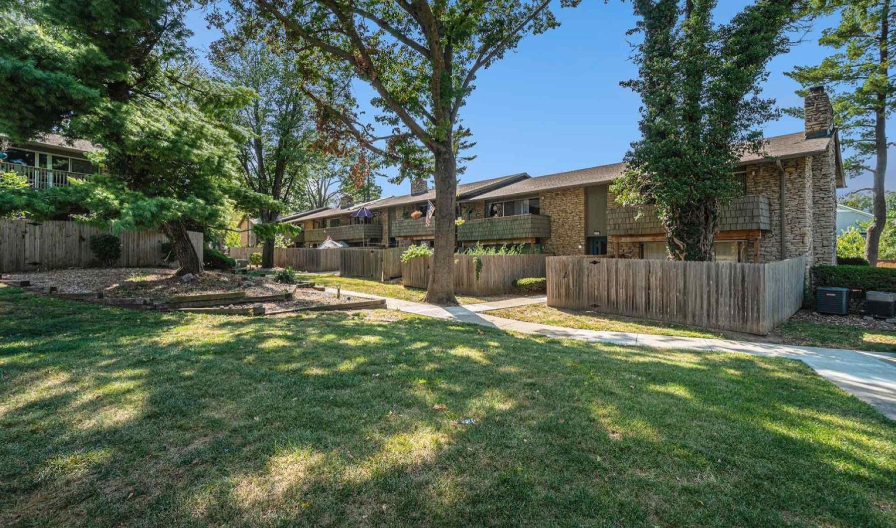 a building with a fence and trees in the front