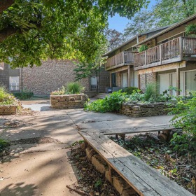 a courtyard with a bench and trees