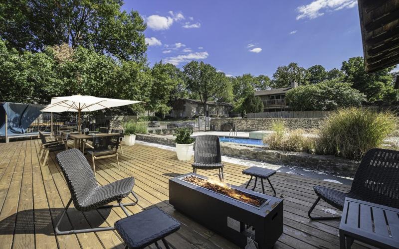 a patio with chairs and tables and a firepit